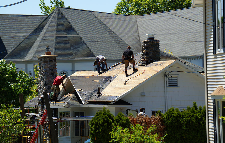 construction workers installing roof shingles in Fredericton, NB